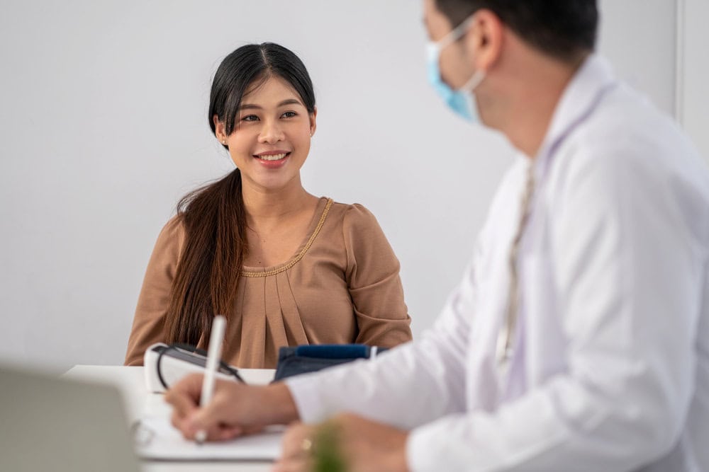 A doctor and patient discussing fertility and anovulation treatment