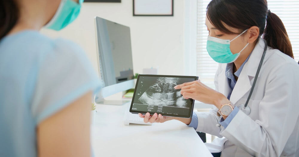 Doctor showing a healthy uterus on ultrasound, ready for embryo implantation in the Doctor showing a healthy uterus on ultrasound, ready for embryo implantation in the uterine cavity.